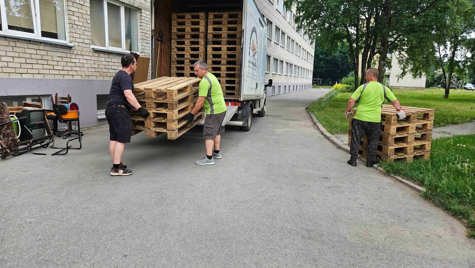 Рабочие загружают отдельно собранные деревянные поддоны.